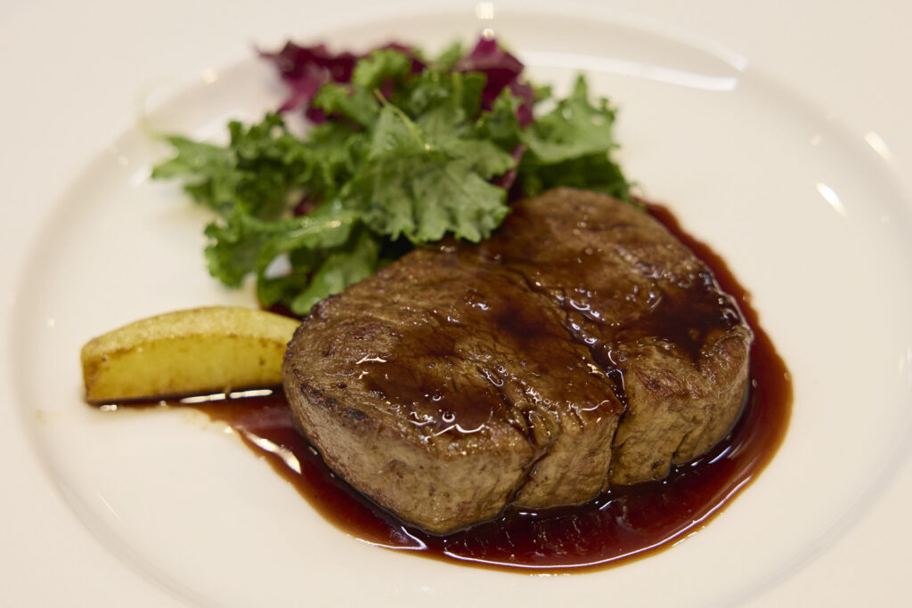 決勝の課題は「⽜フィレの焼き分け」。 ファースト=ミディアムレア、 セカンド=ミディアムという指定に、 同じ⾷材で2⽫の品質を揃える再現⼒が試された。